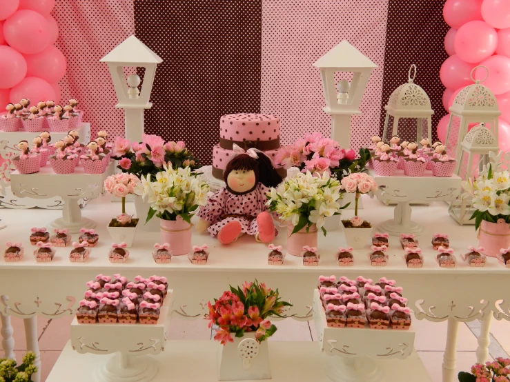 an arrangement of cake, cupcakes and other items on display