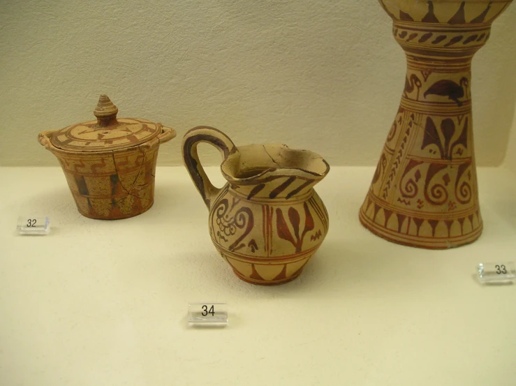 three vases on a table and three jars