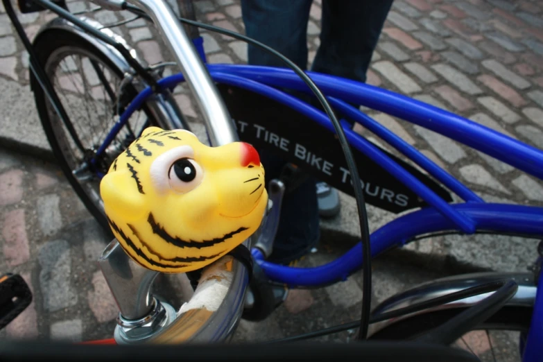 a closeup of a blue bike with a fake head on the handle