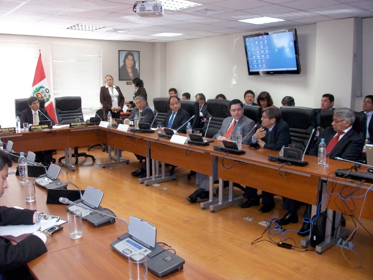 group of business people seated in front of large conference room