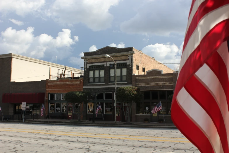 the flag is on top of a pole in front of a building with old glory