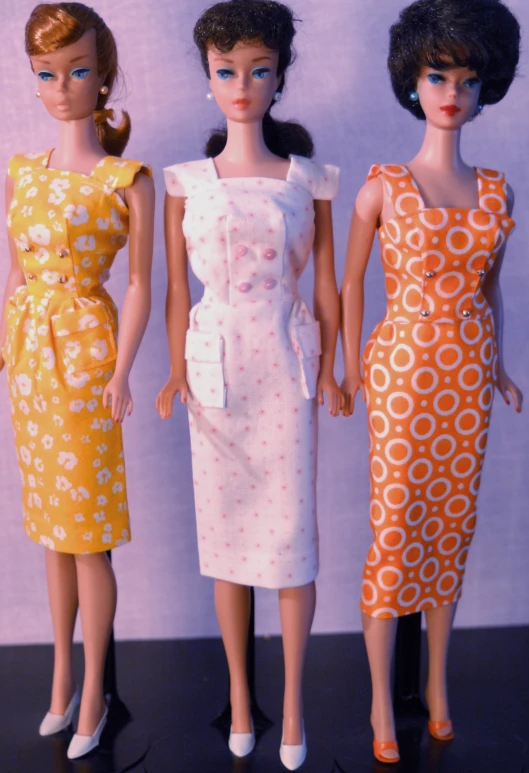 three well dressed dolls, standing next to each other