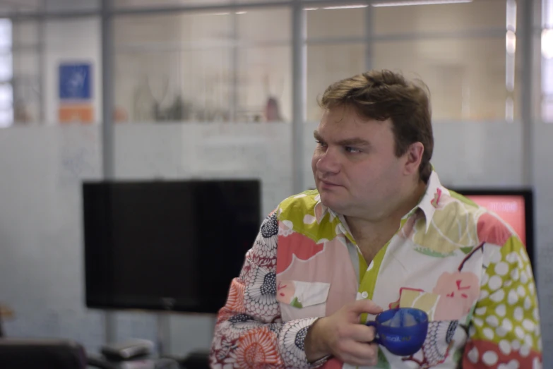 a man in floral shirt playing a game on the nintendo wii