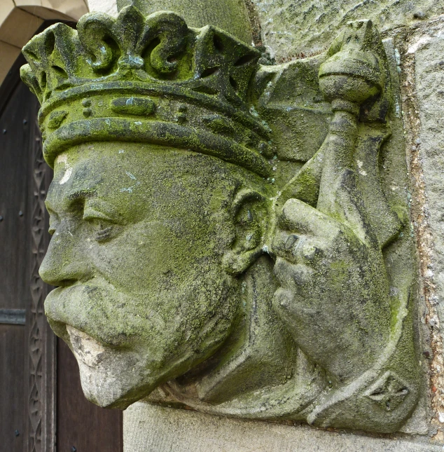 a stone head on the wall of an building