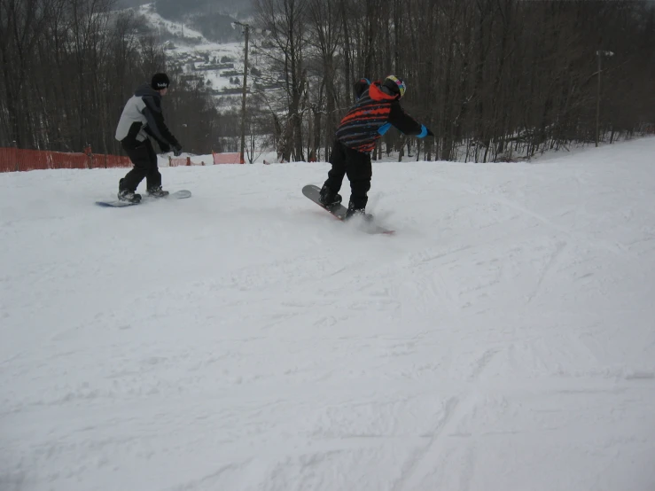 the people are riding down the snowy mountain