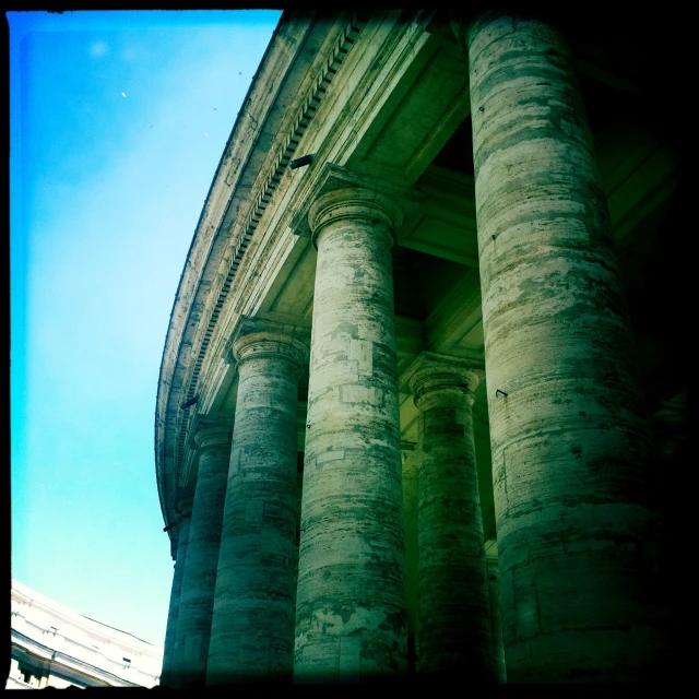 two tall pillars against a blue sky in front of a building