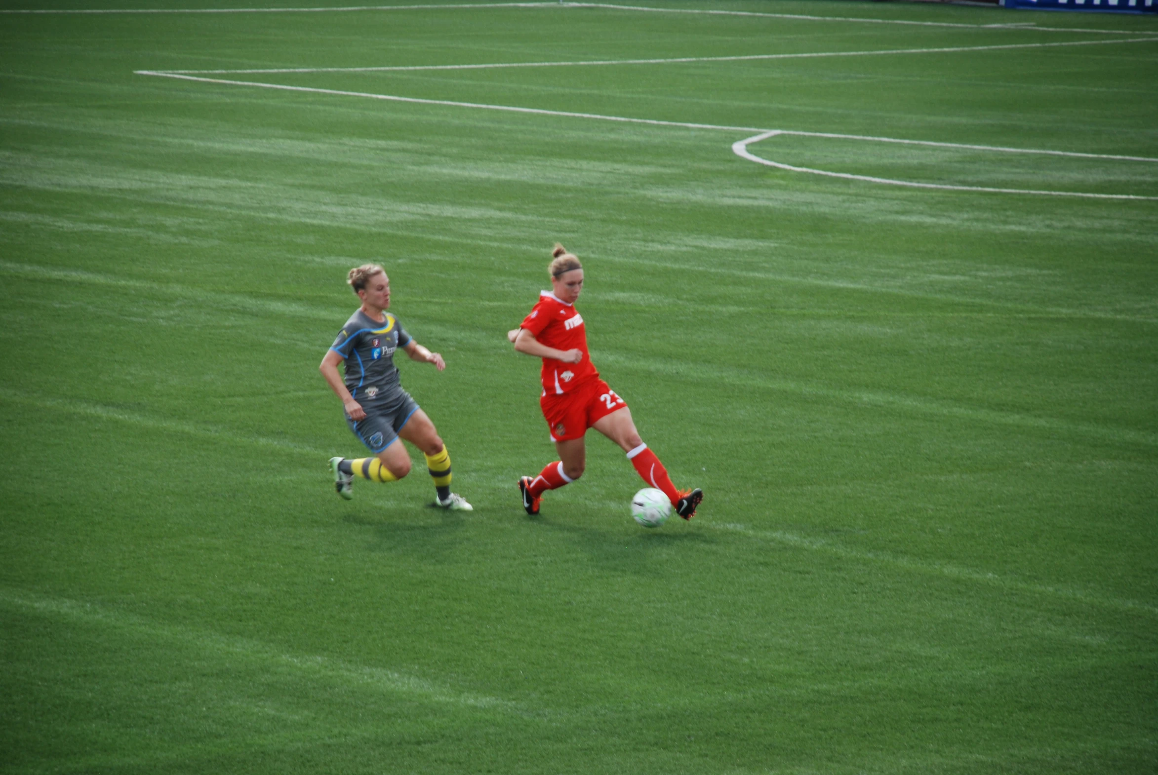 two women are playing soccer on the field