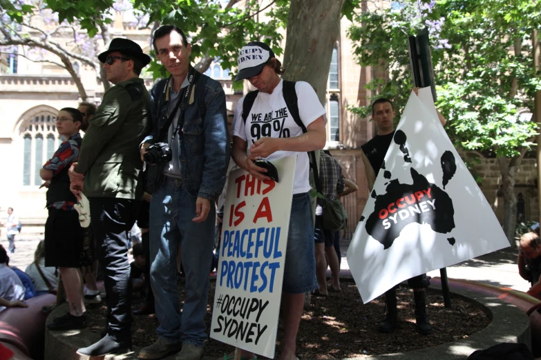 people outside of a building hold protest signs