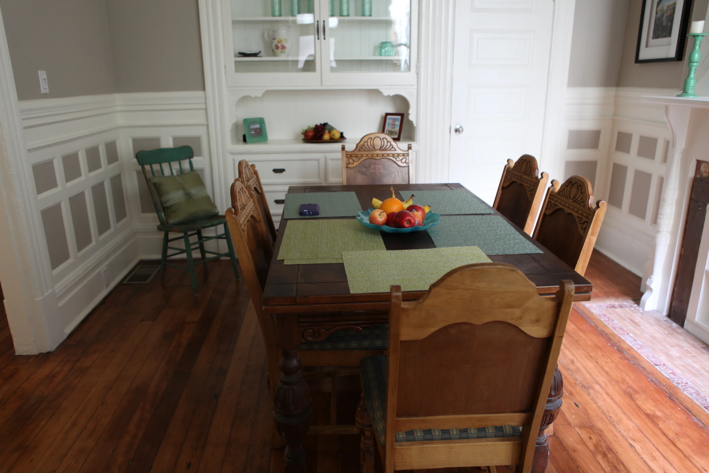 a dining room has a table with chairs and fruits on it