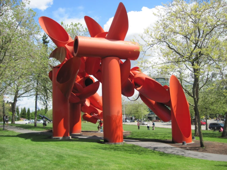 the large orange sculpture stands out on the lawn