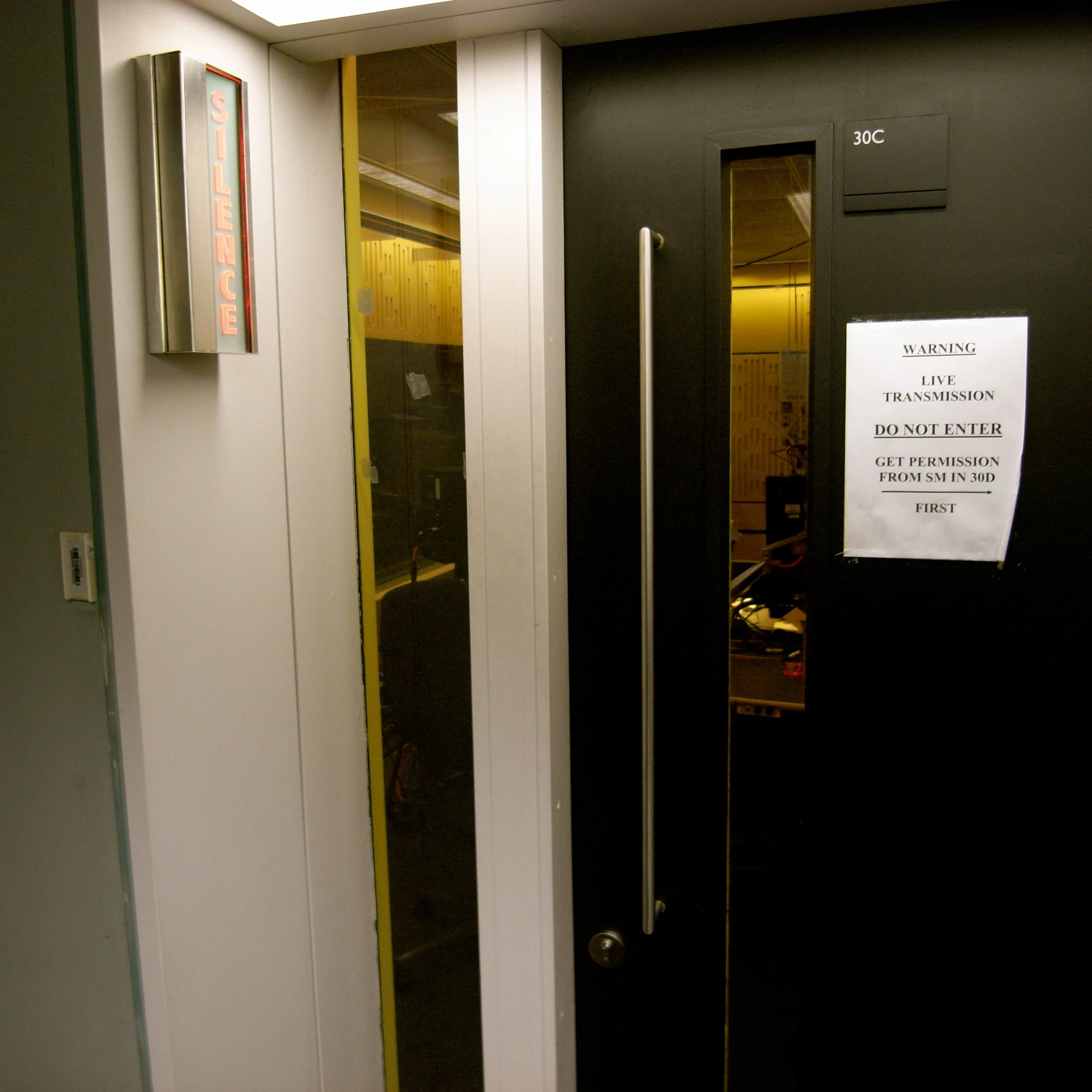 a black door leading to a room with some lights