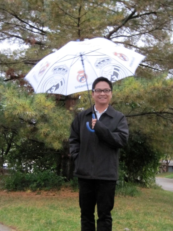 the man is standing in the yard with a white umbrella