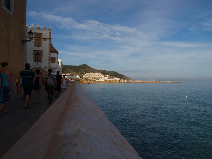 people walking along a walkway looking out to sea