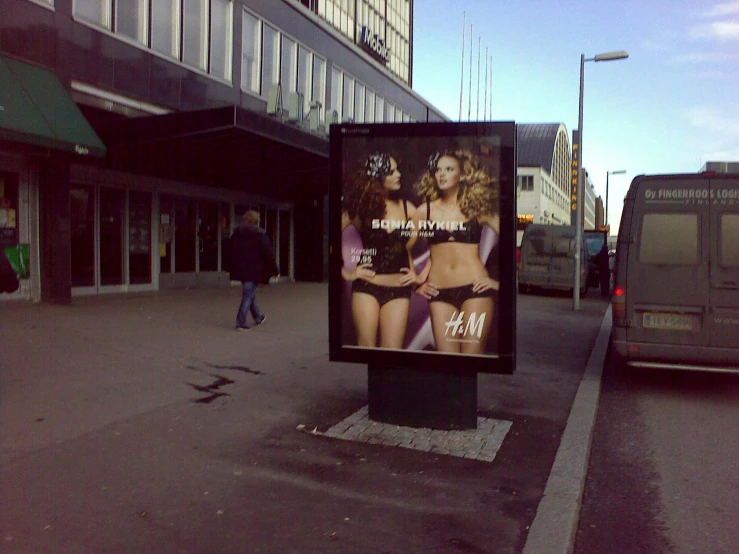 a city sidewalk and a large billboard displaying a strip art ad