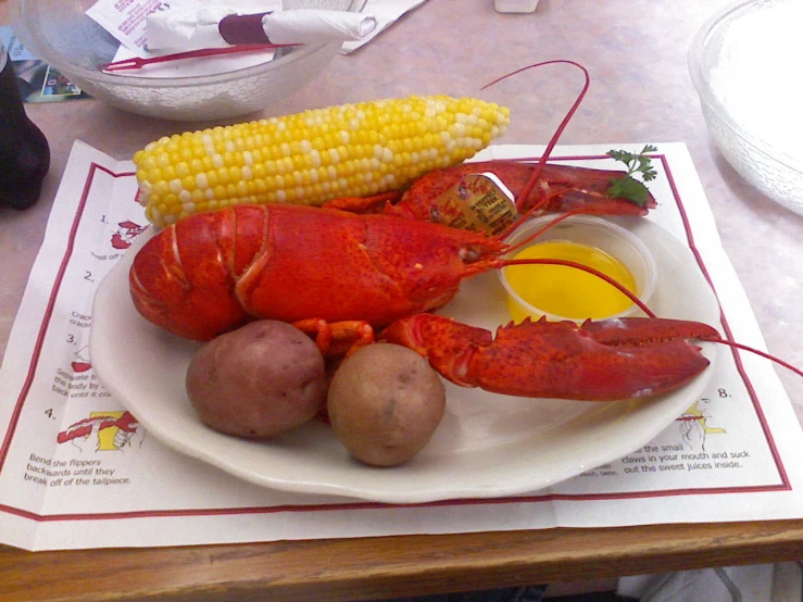 lobster, corn on the cob, and potatoes on a plate