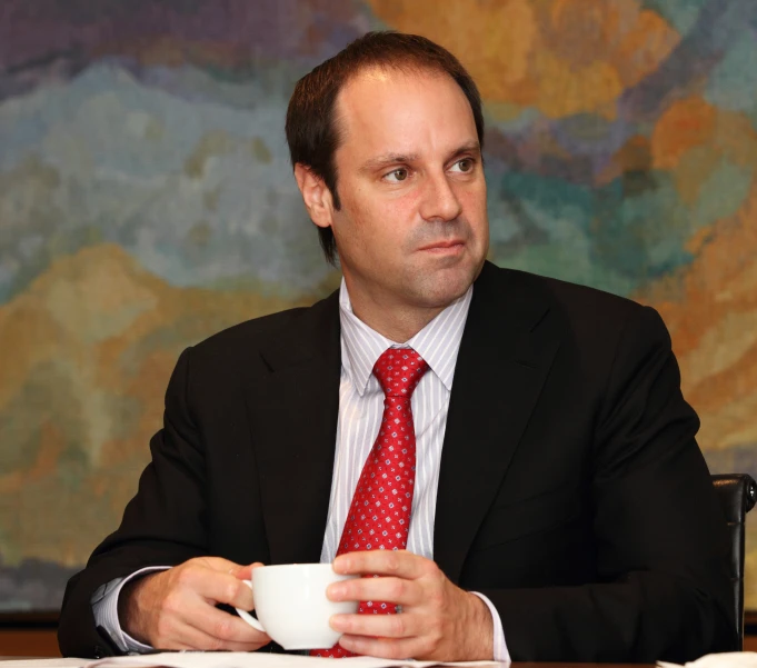 man sitting in an office drinking a cup