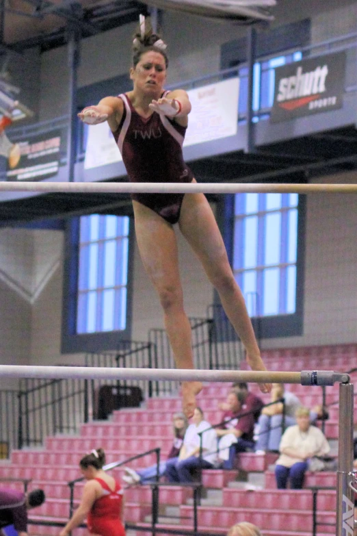 a woman performing an artistic gymnastics trick on bars