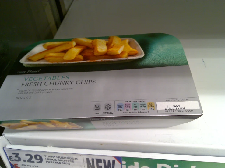 food in a paper tray on top of a box of chips