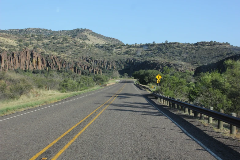 a very wide empty road with mountains in the background