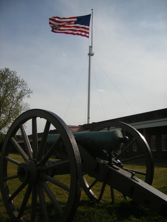 a cannon with a flag flying above it