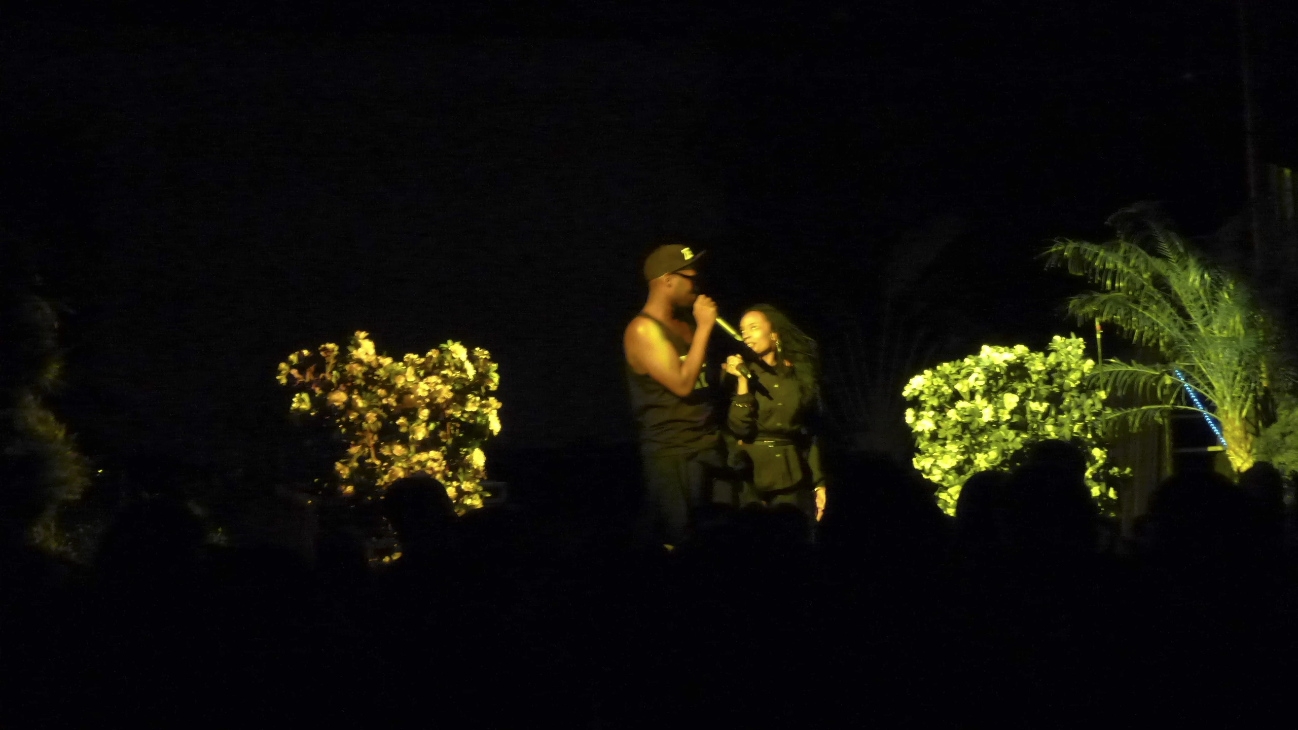 a couple of men standing next to each other in the dark