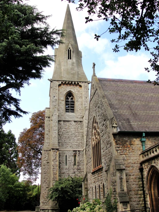 a large church with a tower is surrounded by trees and greenery