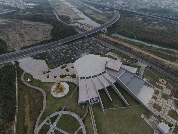 an aerial view shows a circular building near a river