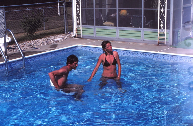 two people play in an empty swimming pool