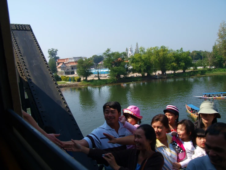 a group of people sit on the edge of a bridge