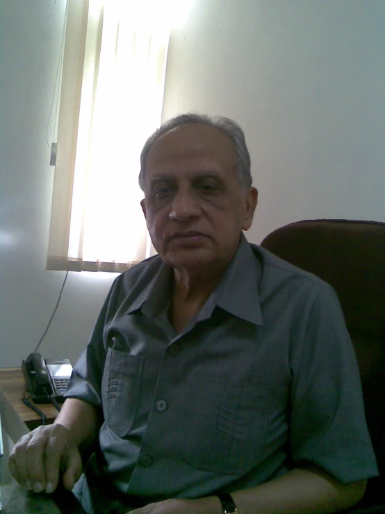 an older man holding a piece of luggage on top of a wooden table