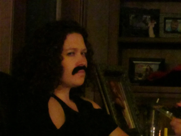 a woman with a mustache drinking some alcohol