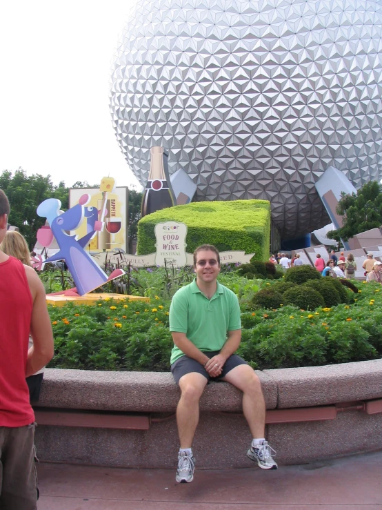 a man sitting in the grass near a giant ball