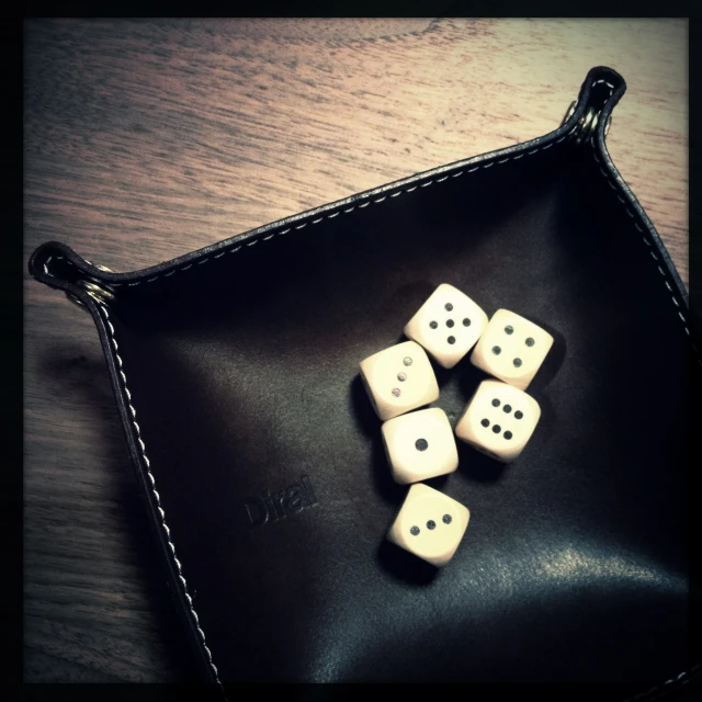 some dice sit on top of a black tray