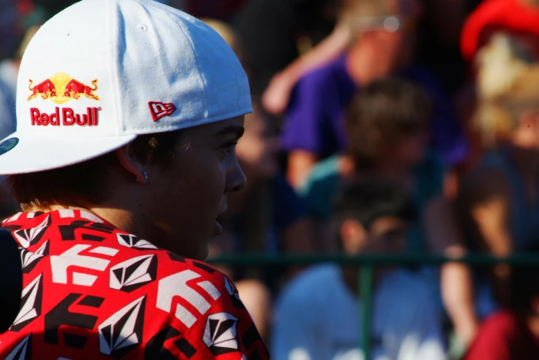 a young man with red bull baseball cap and red bull logo on his hat