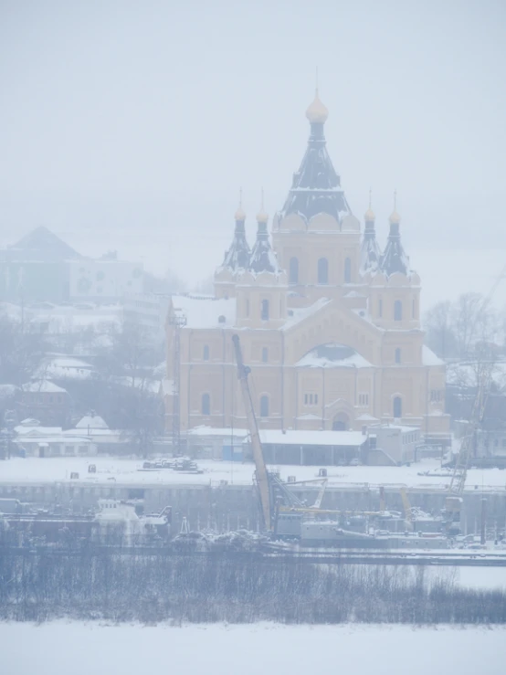 an old building sitting in the snow on top of a hill