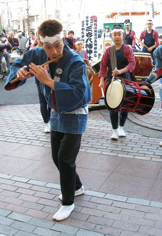 a young man is holding his instruments in front of people