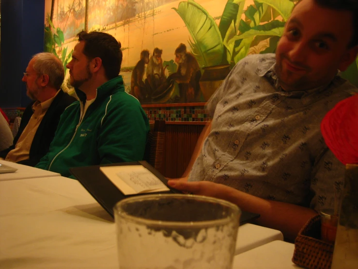 two men in a restaurant sitting at a table with drinks