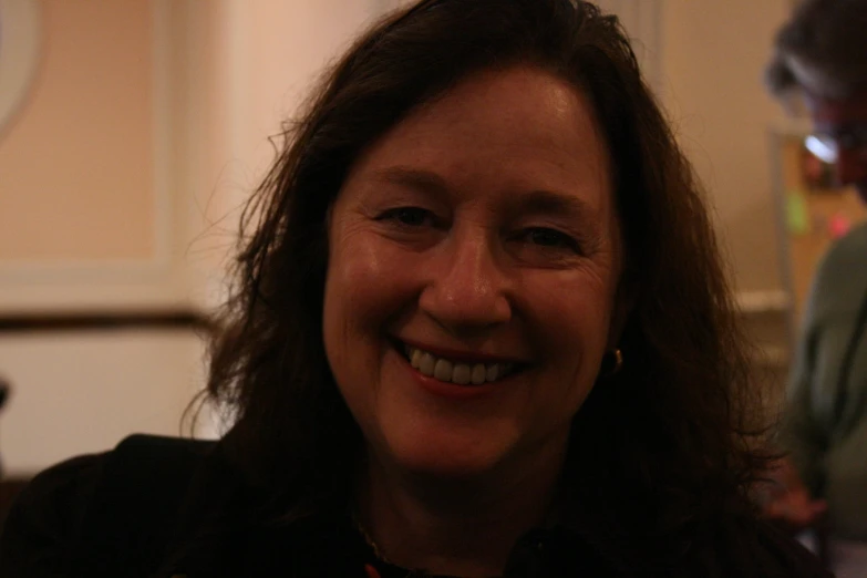 a woman in black jacket smiling at camera