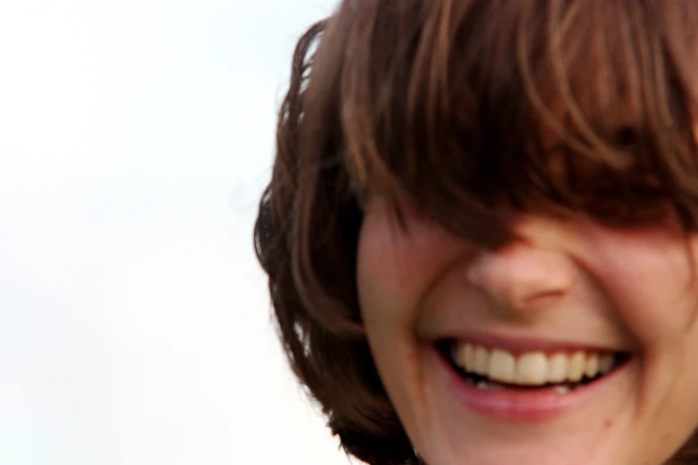 a little girl smiles and has her hair styled with bangs