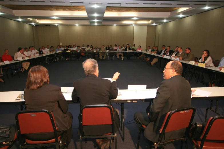 people sitting at tables with speakers and microphones