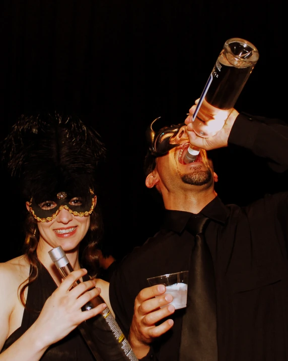 a man and woman wearing masks holding drinks