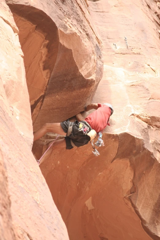 a man climbing on rocks to take a po