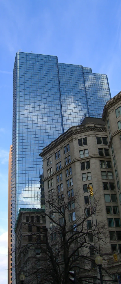 a city skyscr reflecting the sky in its mirrored glass windows