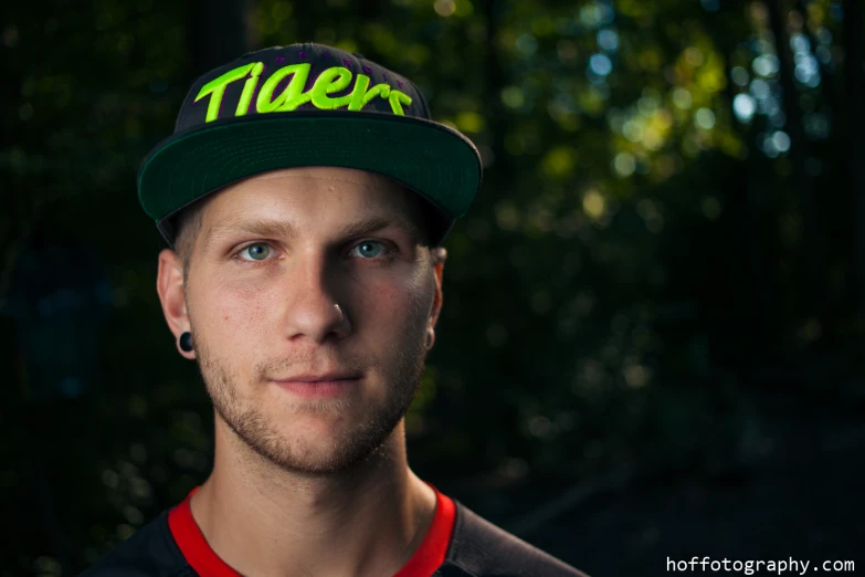 a young man wearing a green and yellow hat