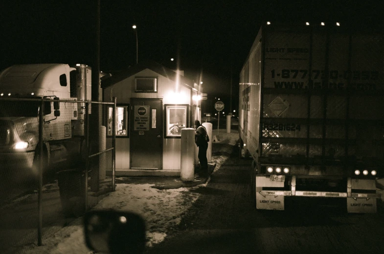 man standing in front of a mailbox at night