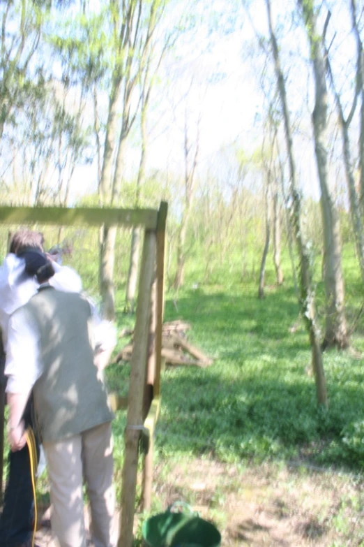 people standing around by a fence in the woods