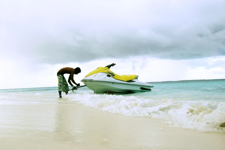 two men work on a motor boat that is in the ocean