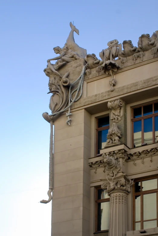 a building has carvings of horses and humans on the top of it