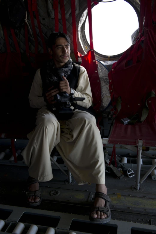 a man sitting down with a camera in his hand