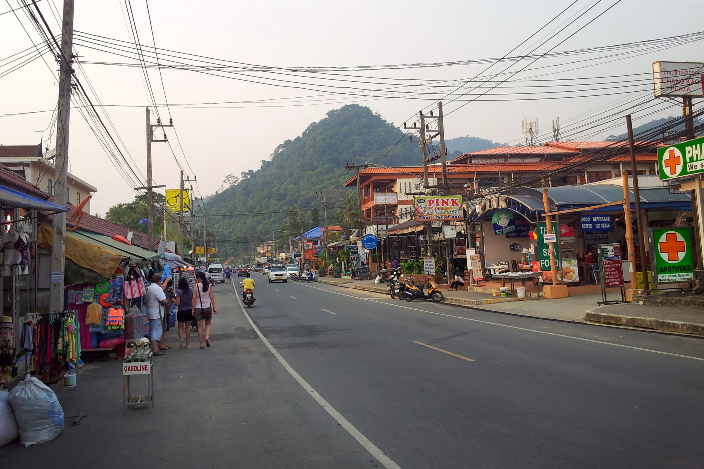 people are shopping on the street by the stores